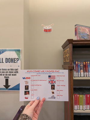 Scavenger hunt flyer helpd in front of a drum put up on the wall.