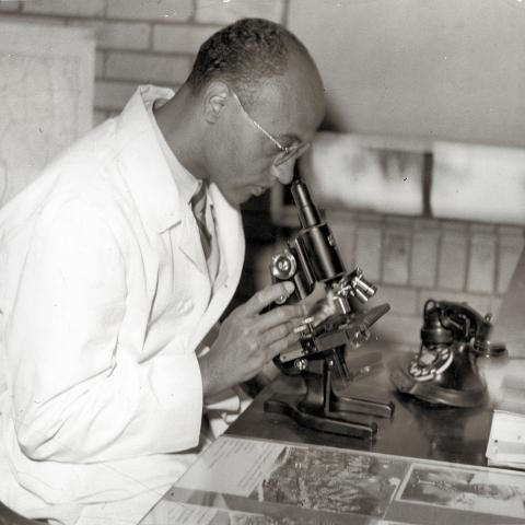 Picture of Dr. Madison Spencer Briscoe with microscope.