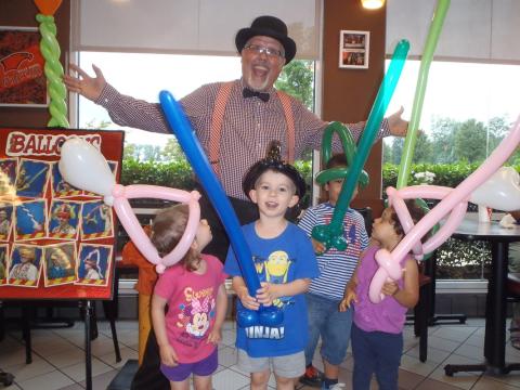 Uncle Bean with kids holding balloon animals