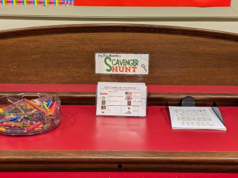 Flyer holder full of Scavenger Hunt flyers in between crayon holder and coloring page holder. 