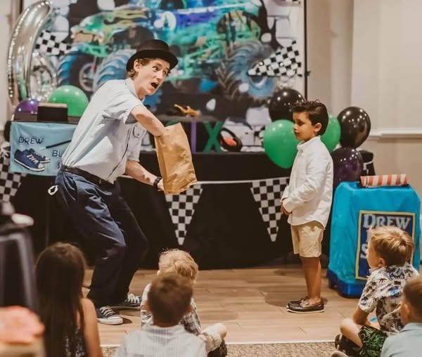 Man reaching hand inside a bag while children watch