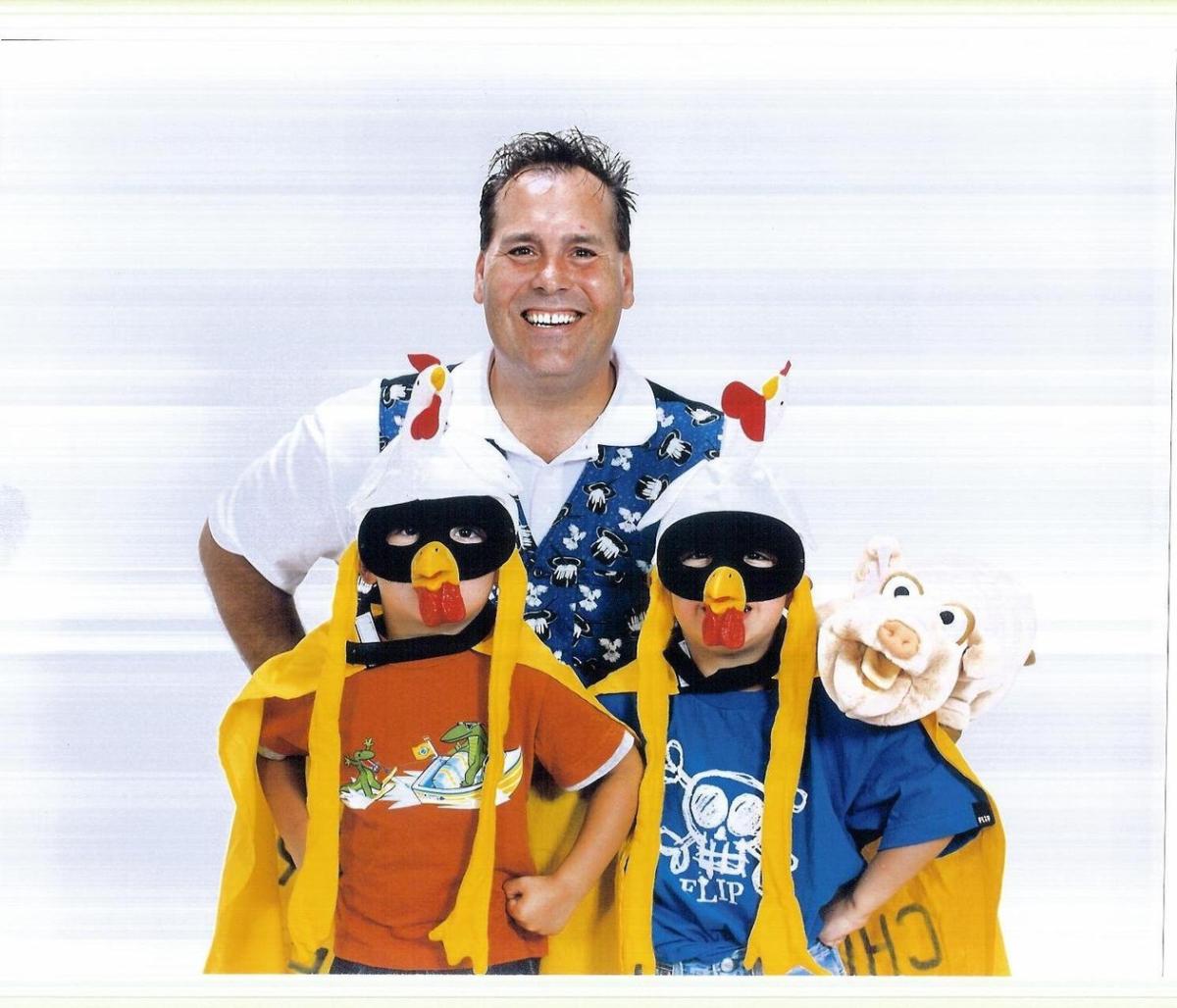 Man with child actors as chickens and a pig