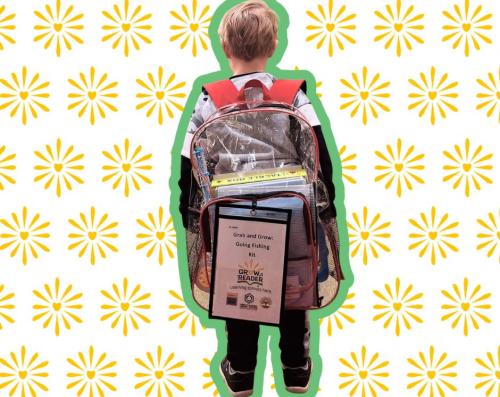 Young boy facing away from the viewer with an almost larger than him clear backpack filled with books and toys and a tag that says "Grab and Grow"